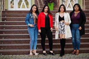 Gruppe von vier glücklichen und hübschen Latino-Mädchen aus Ecuador posierte auf der Straße. foto