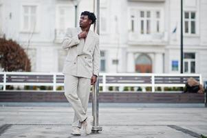 stylischer Afro-Mann im beigen Old-School-Anzug. Modischer junger afrikanischer Mann in Freizeitjacke auf nacktem Oberkörper. foto
