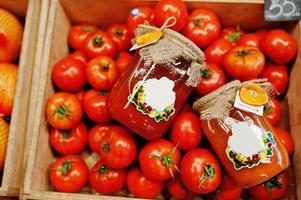 buntes glänzendes frisches gemüse. Tomaten mit hausgemachtem und handgemachtem Tomatensaft aus der Dose im Regal eines Supermarkts oder Lebensmittelgeschäfts. mit Liebe gemacht. foto