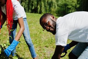 gruppe glücklicher afrikanischer freiwilliger, die baum im park pflanzen. afrika-freiwilligenarbeit, wohltätigkeit, menschen und ökologiekonzept. foto