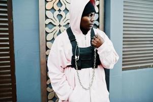 stilvoller afroamerikanischer mann im urbanen stil in rosa hoodie posiert. Afro-Rapper-Typ. foto