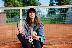 junge sportliche Spielerin mit Tennisschläger auf dem Tennisplatz. foto