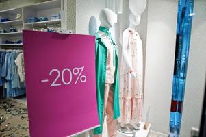 Schaufensterpuppen im farbenfrohen Bekleidungsgeschäft für Frauen. Brandneue, moderne Boutique mit 20-prozentiger Verkaufstafel. foto