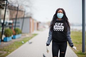 afrikanisches mädchen im park, das medizinische masken trägt, schützt vor infektionen und krankheiten coronavirus-virus-quarantäne. foto