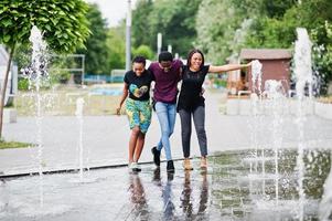 drei afroamerikanische freunde, die auf brunnen gehen. zusammen Spaß haben. foto