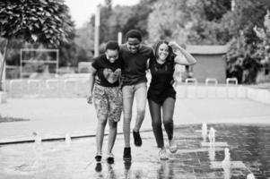 drei afroamerikanische freunde, die auf brunnen gehen. zusammen Spaß haben. foto
