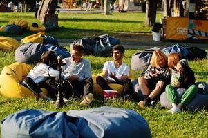 junge multiethnische gruppe von menschen, die filme im poof im open-air-kino ansehen. foto