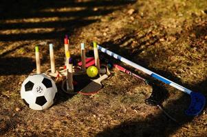 Kinder spielen auf Gras. Holzringwurf, Ball, Unihockey, Tischtennisschläger. foto