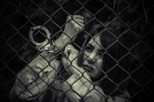 porträt von frauen, die verzweifelt das eiserne gefängnis fangen wollen, gefangenenkonzept, thailänder, hoffen, frei zu sein, wenn sie gegen das gesetz verstoßen und verhaftet und eingesperrt würden. foto