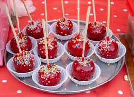 süße glasierte rote Toffee-Kandinapfel auf Stöcken zum Verkauf auf Bauernmarkt oder Landmesse. Thanksgiving und Halloween hausgemachte rote Karamell-glasierte Toffee-Äpfel mit Stöcken foto