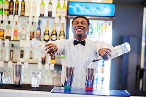 afroamerikanischer barkeeper, der hinter der cocktailbar arbeitet. Zubereitung von alkoholischen Getränken. foto