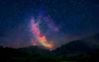 Milchstraße und rosa Licht in den Bergen. nacht bunte landschaft. Sternenhimmel mit Hügeln im Sommer. schönes Universum. Weltraumhintergrund mit Galaxie. Reisehintergrund foto