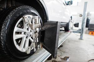 amerikanisches suv-auto auf stand für radausrichtungs-sturzprüfung in der werkstatt der servicestation. foto