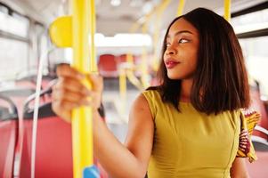 junge stilvolle afroamerikanische frau, die in einem bus fährt.