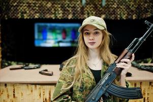 Mädchen mit Maschinengewehr an den Händen auf dem Schießstand. foto