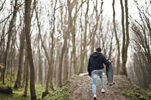 arabischer Streetstyle-Mann mit Brille und Longboard auf Holz. foto