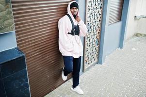 stilvoller afroamerikanischer mann im urbanen stil in rosa hoodie posiert. Afro-Rapper-Typ. foto