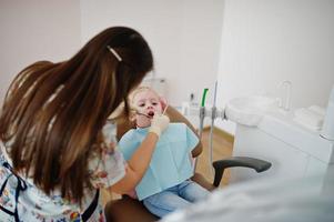 kleines Mädchen am Zahnarztstuhl. Kinder zahnärztlich. foto