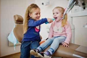 zwei süße kleine Mädchen am Zahnarztstuhl. Kinder zahnärztlich. foto