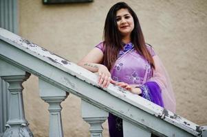 indisches hinduistisches Mädchen im traditionellen violetten Saree posierte auf der Straße. foto