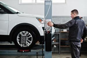 Automechaniker setzt amerikanisches SUV-Auto zur Diagnose und Konfiguration Sturzprüfung in der Werkstatt der Tankstelle.. foto