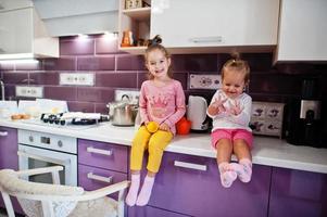 zwei schwestern kinder kochen in der küche, glückliche kindermomente. foto