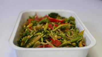 sautierte Papayablätter, indonesisches Essen, serviert in einem Aluminiumplatz auf weißem Hintergrund foto