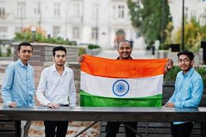 Gruppe von vier südasiatischen indischen Männchen mit Indien-Flagge. foto