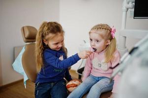 zwei süße kleine Mädchen am Zahnarztstuhl. Kinder zahnärztlich. foto