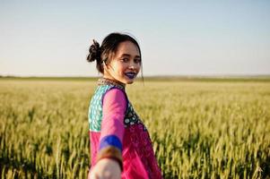 zartes indisches mädchen im saree, mit violetten lippen, die bei sonnenuntergang auf dem feld posierten. modisches Indien-Modell. foto