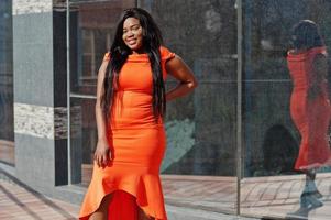 afroamerikanerfrau modell xxl im orangefarbenen kleid. foto