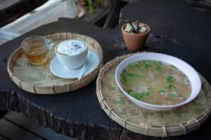 Frühstück mit gekochtem Reis und Kaffee auf altem Holztisch foto