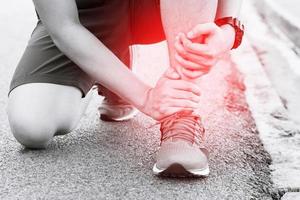 Läufer berührt schmerzhaft verdrehten oder gebrochenen Knöchel. Trainingsunfall eines Sportlers. Sport Running Knöchel verstauchte Verstauchung verursachen Verletzungen. foto