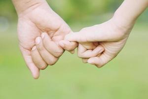 frau und mann halten sich an den händen, glücklicher paarliebhaber im park. foto