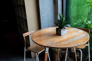 Couchtisch oder Freizeit-Ecktisch mit Tageslicht aus dem Fenster. Pflanze und Vase sind auf dem Tisch dekoriert. foto