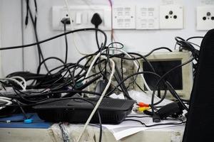 Konzept der Unordnung in den elektrischen Kabeln des Büros auf dem Tisch foto
