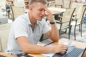 junger Mann sitzt im Café foto