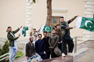 Gruppe pakistanischer Männer, die traditionelle Kleidung Salwar Kameez oder Kurta mit pakistanischen Flaggen tragen. foto