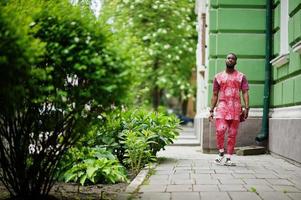 Porträt eines schwarzen jungen Mannes, der afrikanische traditionelle rote bunte Kleidung trägt. foto