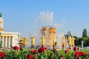 moskau, russland, 2019 - der brunnen der völkerfreundschaft auf der vdnkh-ausstellung in moskau und blühende rote rosen foto