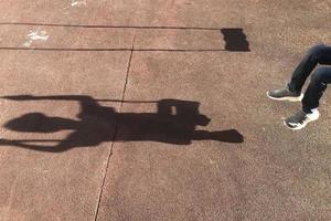 Schatten des schwingenden Jungen auf dem Spielplatz foto