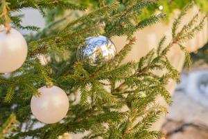 nahaufnahme des weihnachtsbaums, der mit goldenen und weißen kugeln geschmückt ist. hintergrund des neuen jahres foto