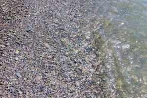 Kieselküste. Küste mit transparentem Wasser und kleinen Steinen foto