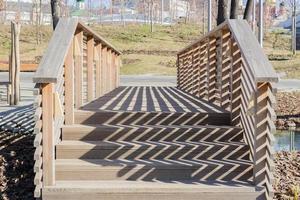 Holzbrücke im Park und Geländer harte Schatten foto