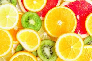 Zitrusscheiben - Kiwi, Orangen und Grapefruits auf weißem Hintergrund. Früchte Hintergrund foto