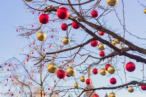 weihnachts- und neujahrsferienhintergrund. Baum ohne Blätter, verziert mit roten und goldenen Kugeln foto