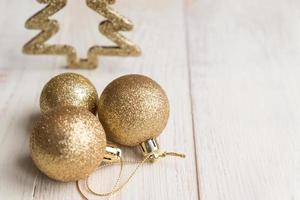 neujahrs- und weihnachtshintergrund - drei goldene kugeln auf holzhintergrund. foto