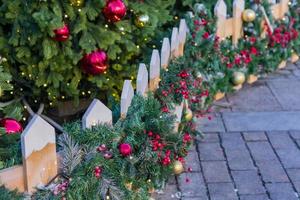 Weihnachten im Freien Dekoration des Zauns. zweige mit kugeln und girlande foto