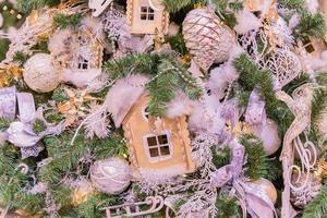 weihnachts- und neujahrsferienhintergrund. weihnachtsbaum geschmückt mit weißen und goldenen kugeln, jinger häusern, kegeln und bändern. feierkonzept foto