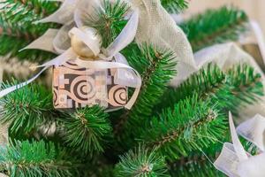 weihnachts- und neujahrsferienhintergrund. weihnachtsbaum mit girlande und geschenkbox mit schleife foto